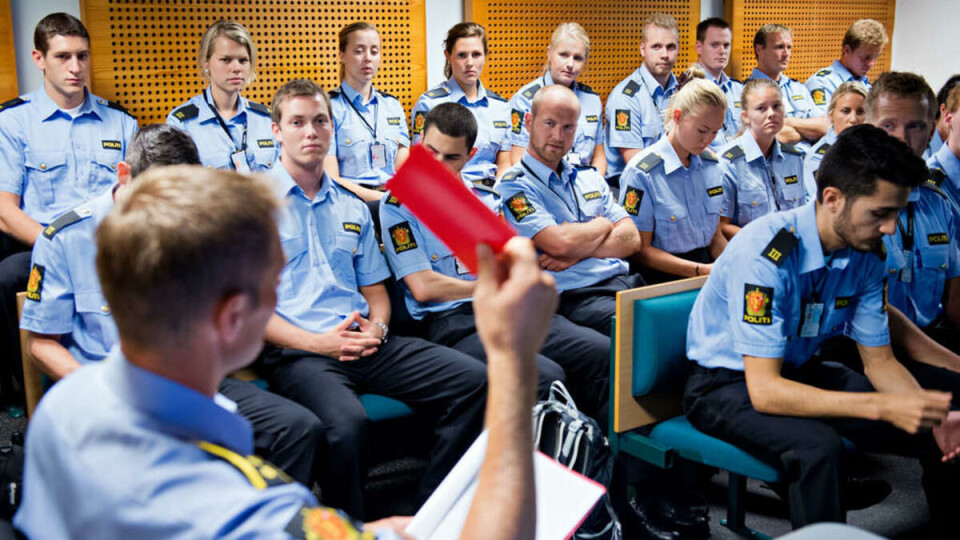 Våpeninstruks: Jørn Haagensen viser frem den røde våpeninstruksboka til politistudenter på simulatortrening. Mange studenter ønsker mer slik trening.