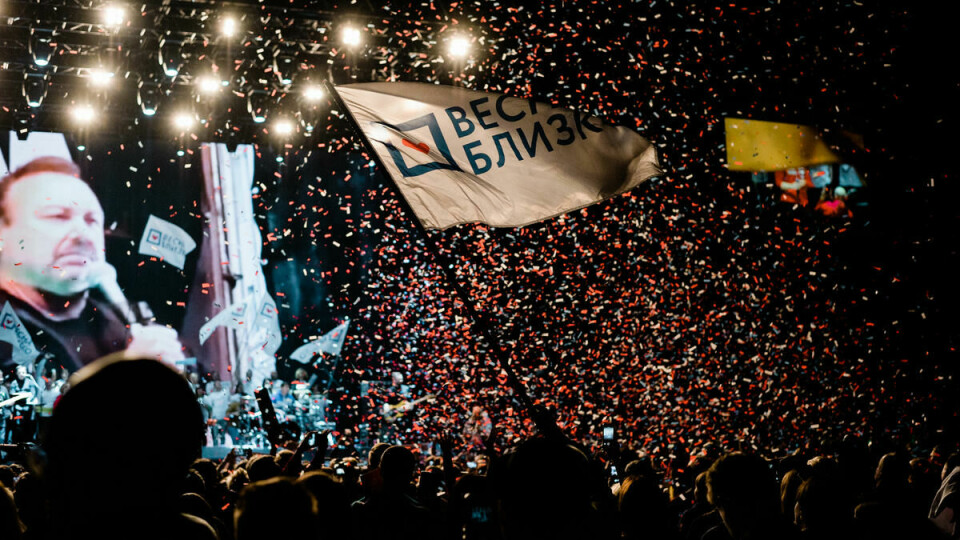 VÅREN KOMMER SNART? Et stort flagg vaier over unge og gamle Sobtsjak-tilhengere i Adrenaline Stadium i Moskva. Mange bærer den samme påskriften «Våren kommer snart», i håp om et politisk maktskifte i Russland.