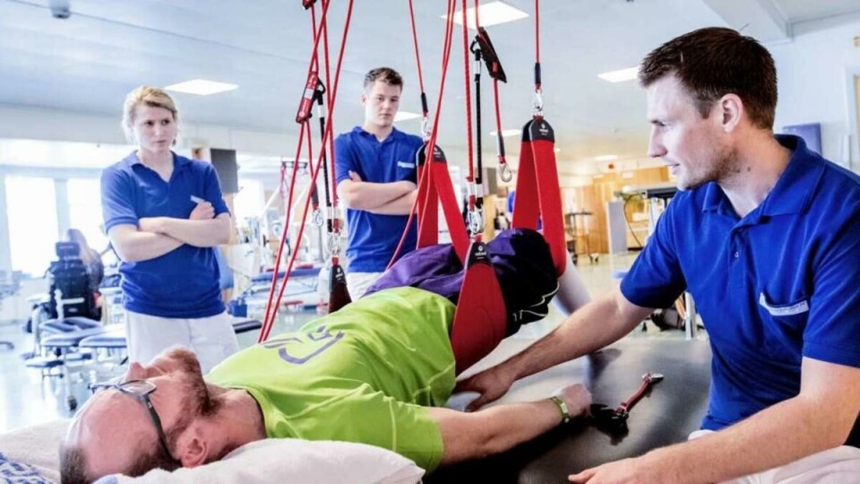 Litt høyere: – Kom igjen! Litt høyere med rumpa, sier Andersen mens Nebbneset skjærer grimaser der han ligger på fysioterapisenga. Her med fysioterapistudentene Hannah Midtbø og Terje Hasselø og fysioterapeut Ole Christian Andersen.