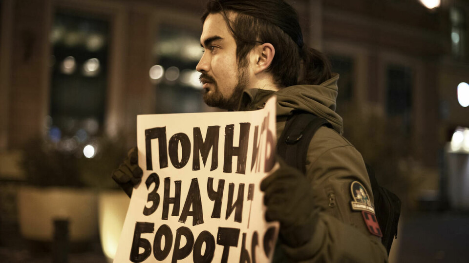 Du må ikke glemme: Vlad står smilende med sitt budskap midt i St. Petersburg og virker heller uaffisert av det store politioppbudet. – Det er jeg helt vant til, sier han. Skiltet sier «Å huske er å kjempe. Stopp fascismen!»