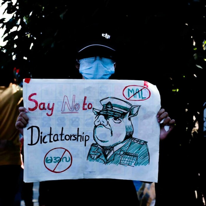 Frihetskamp: En gateprotestant i Yangon viser fram en karikatur av militærsjef Min Aung Hlaing tidlig i demonstrasjonene. Siden militæret grep makten i Myanmar 1. februar har tusenvis av unge tatt til gatene for å demonstrere.