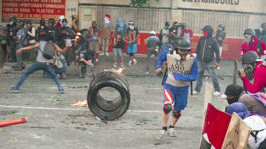 Te Amo Venezuela: «Jeg elsker deg Venezuela» står det på genseren til demonstranten som løper for å komme seg bak barikaden under en protest i sommer. Te Amo Venezuela: «Jeg elsker deg Venezuela» står det på genseren til demonstranten som løper for å komme seg bak barikaden under en protest i sommer.