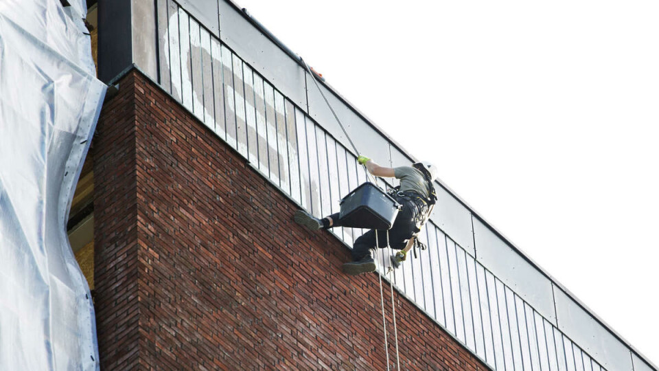 THROW-UP: Taggeren Gosha angrep sørsiden av bygget med sin hvite maling. Her forsøker en UiO-ansatt å fjerne grafittien. Foto: Hanne Marie Lenth Solbø
