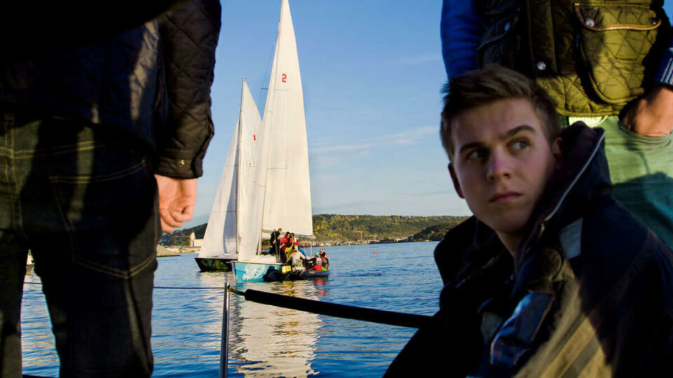 Stille vann: I publikumsbåten sitter Arne Rånnerud og speider etter vind. I bakgrunn konkurrerer seilbåtene.