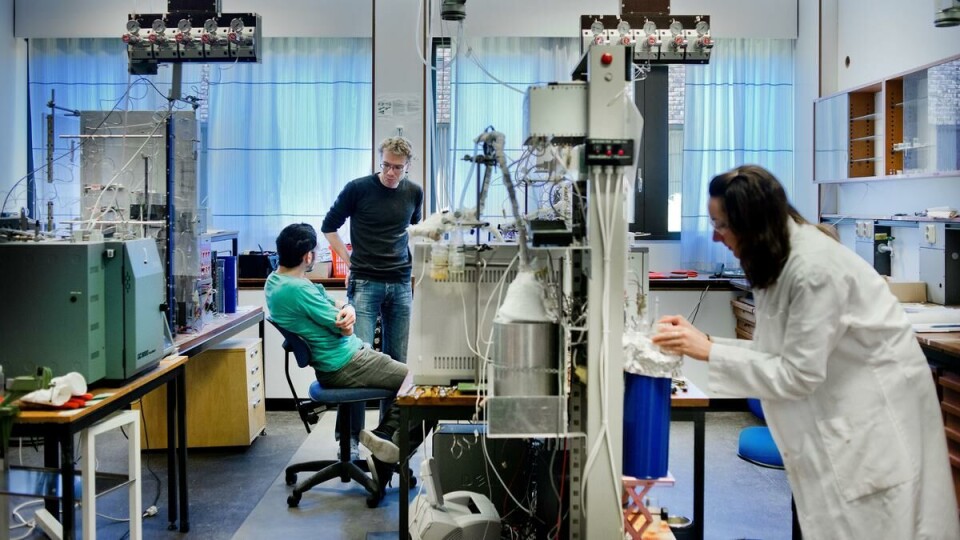 Eksperiment: Doktorgradsstudent Rachel Smith sjekker temperatur på en gassbeholder og putter en liten isbit oppi for å få ned temperaturen mens postdoktor Bjørn Tore Bleken (stående) og Pablo del Campo diskutererer noe viktig.