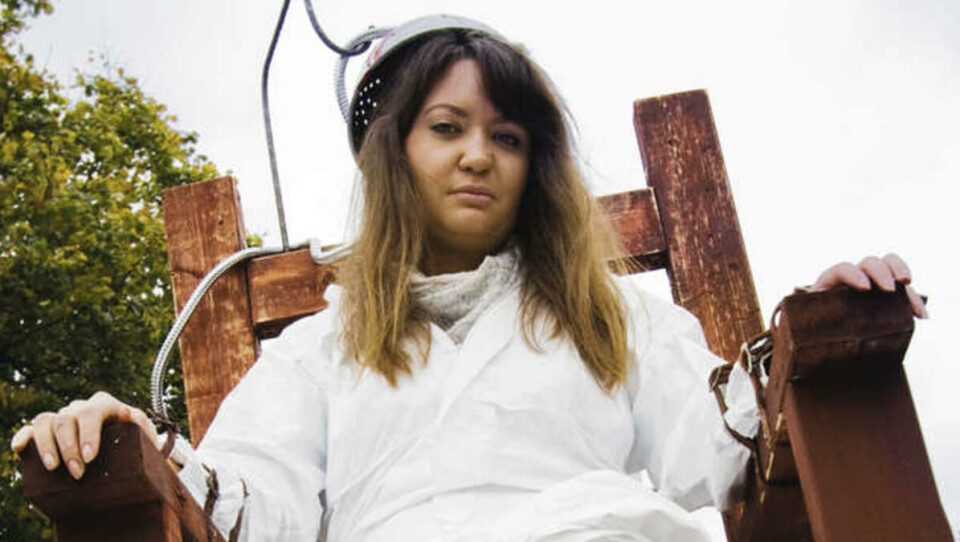 VEKKER OPPSIKT: Anette Helleborg har tatt plass i den elektriske stolen for å vekke nysgjerrighet. Stuntet fungerer bra, for det er mange engasjerte studenter som tar tar turen innom Amnestys stand.