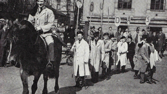 AD UNDAS: Mentz Schulerud bærer det første skiltet når studentene reklamerer for revyen Ad Undas på Karl Johan i 1946.