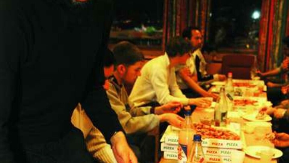 DISKUSJONER RUNDT EN HALALPIZZA: Maten glir ned mens guttene diskuterer politikk og vitenskap. -- Vi håper det kommer flere folk etter hvert som vi arrangerer flere fester, sier Mahmood Ahmad. Med tanke på hvor mange muslimer det er i akademia, er det altfor få her, mener han.