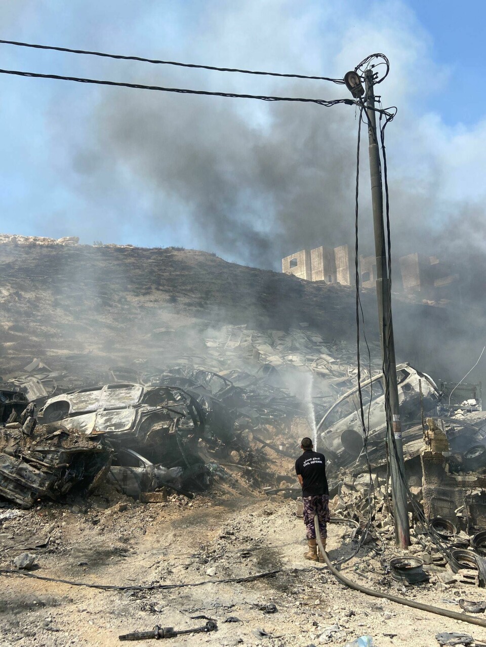 Opp i røyk: En palestinsk mann slukker flammene etter sammenstøt mellom palestinske demonstranter og IDF.